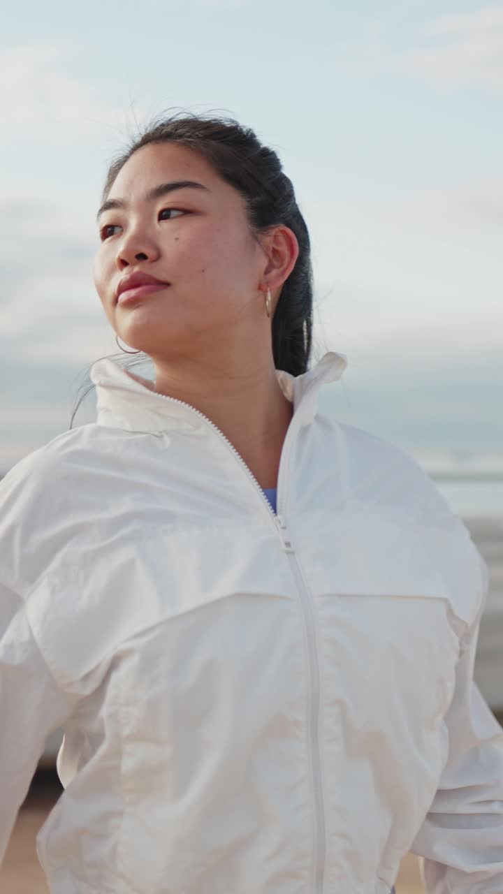 ビーチで屋外ストレッチをする若いアジア人女性。