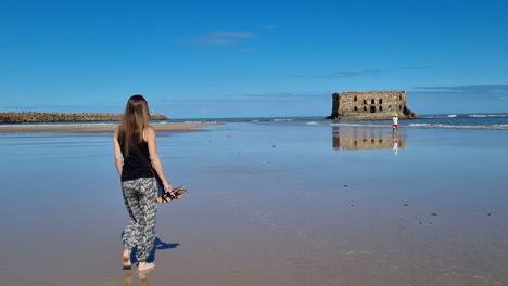 Chica-Con-Cabello-Largo-Camina-Hacia-La-Playa-En-Casa-Del-Mar,-Tarfaya,-Marroco