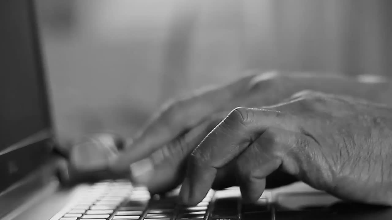 typing on a laptop keyboard paying a bill in office working from home with people stock video stock footage