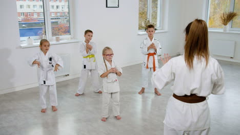 niños en kimono blanco en la clase de artes marciales