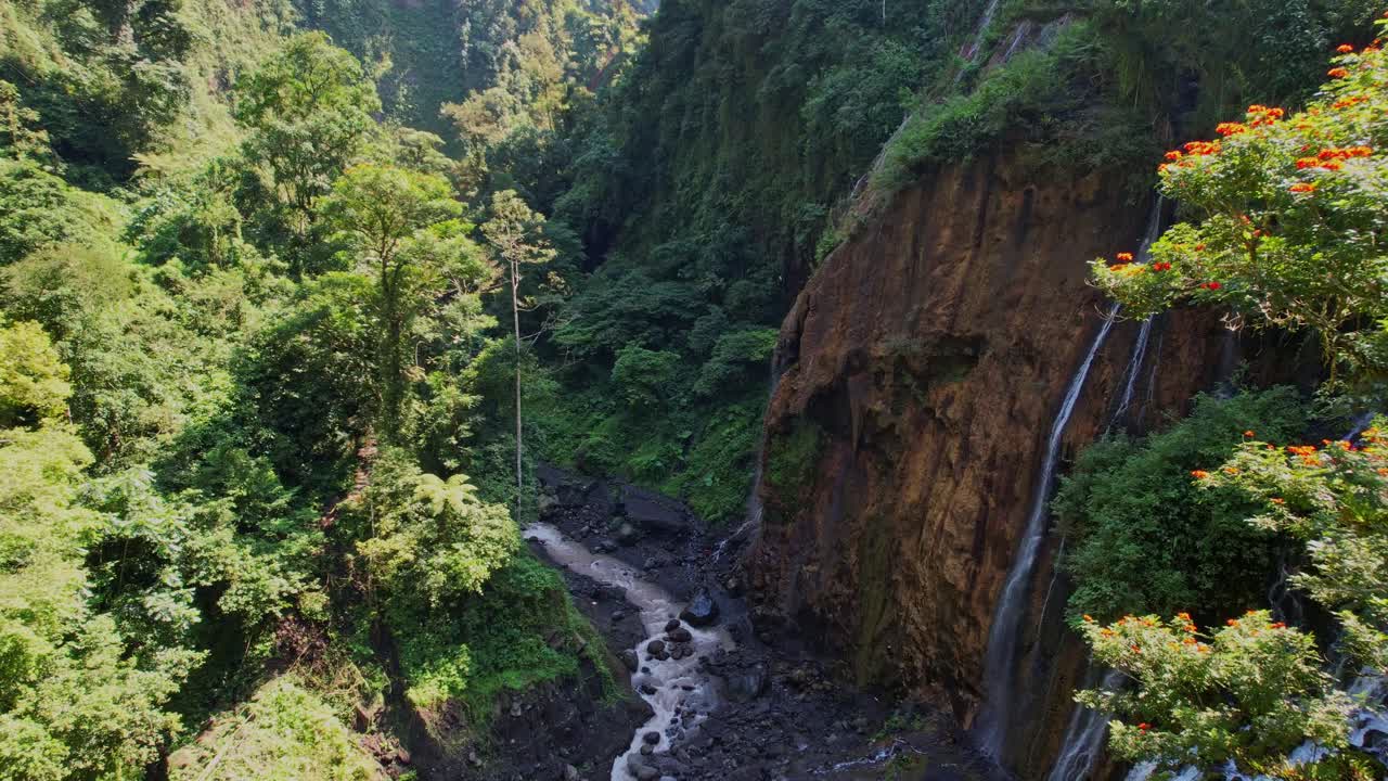 Serene waterfall view in lush green jungle near active volcano in Java