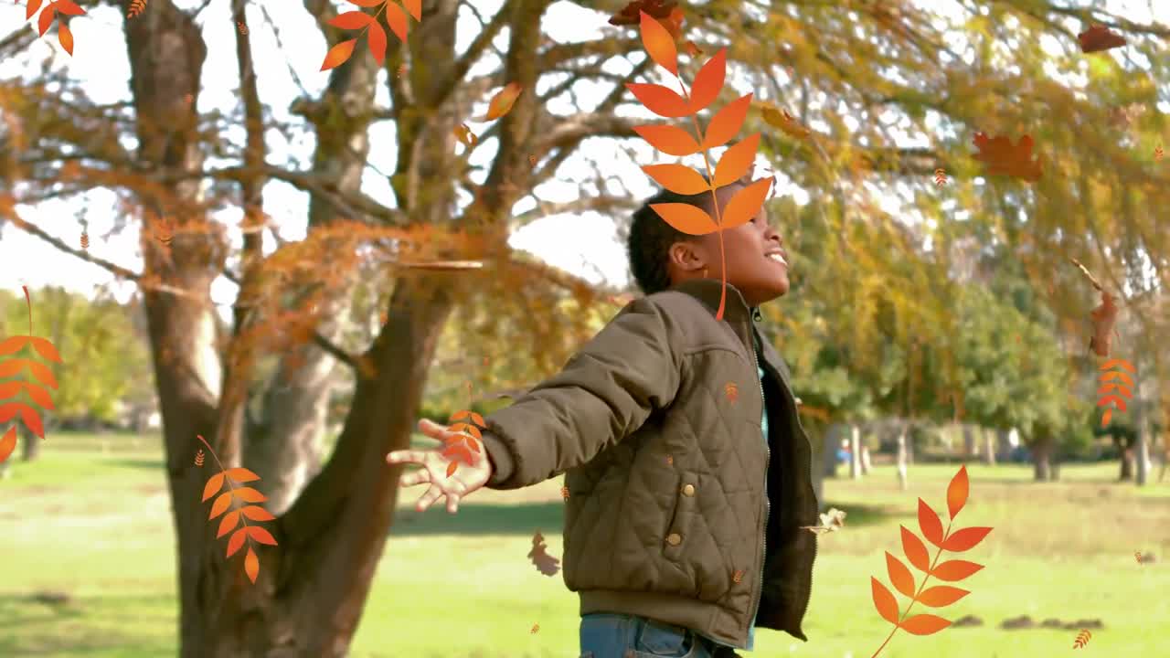 animación de hojas de otoño que caen sobre un niño afroamericano feliz en el parque de otoño