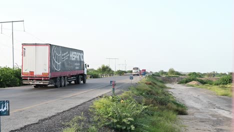 Aufschlussreiche-Aufnahme-Der-Zahlreichen-Lastwagen,-Die-An-Einem-Sonnigen-Tag-Auf-Der-Autobahn-Von-Belutschistan-In-Pakistan-Fahren