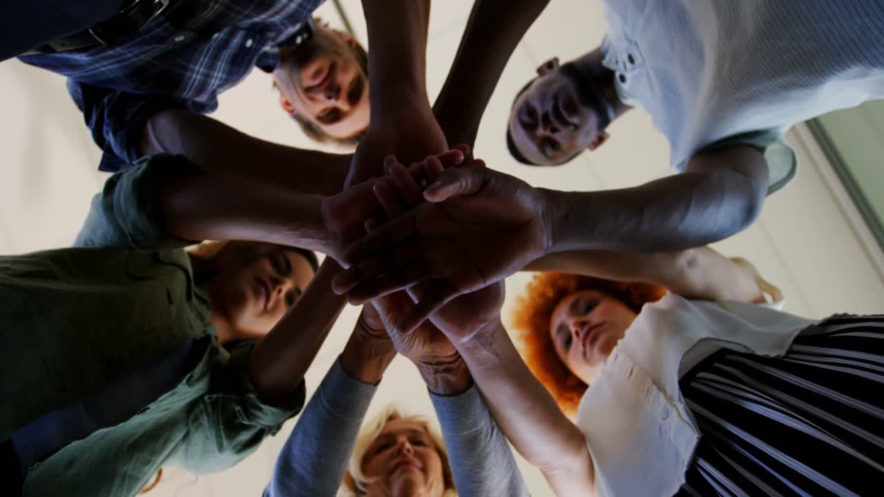 equipo de ejecutivos formando una pila de manos