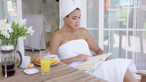 una joven hermosa relajándose con un libro.