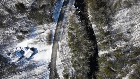 Tracking-view-of-winding-road-and-rushing-river-in-a-winter-climate