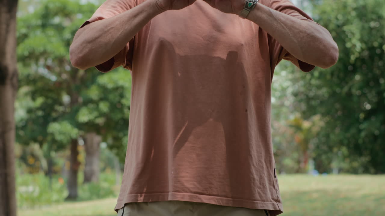 Caucasian Man Performing Tai Chi Exercises Alone in Park