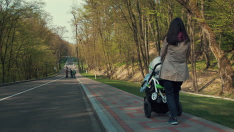 young mother walking with baby carriage