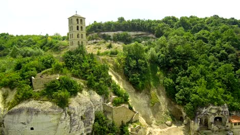 drone takes off along the cliff with the monastery