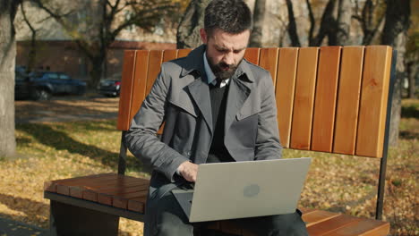 businessman working on laptop in park