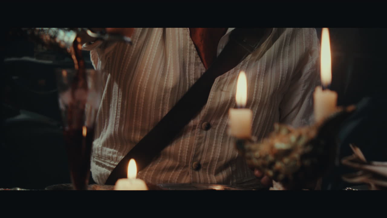 An old pirate eats and drinks inside the sailing ship cabin