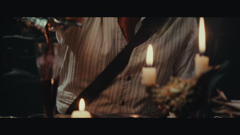 an old pirate eats and drinks inside the sailing ship cabin