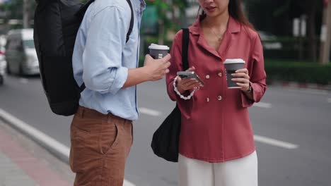 couple on a city street with coffee and phones