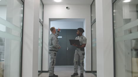 Maintenance Workers in Office Corridor