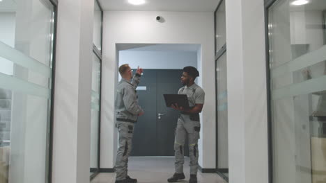 maintenance workers in office corridor