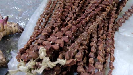 Sun-dried-betel-nut-on-a-string-for-sale-at-a-local-market-on-a-tropical-island-in-Timor-Leste,-South-East-Asia