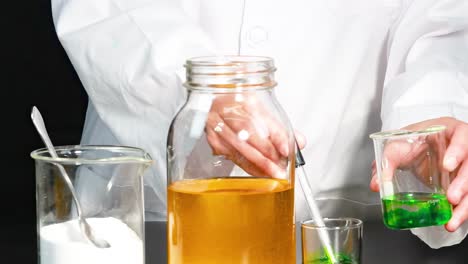 a visual demonstration of combining green liquid with a yellow solution using a dropper.