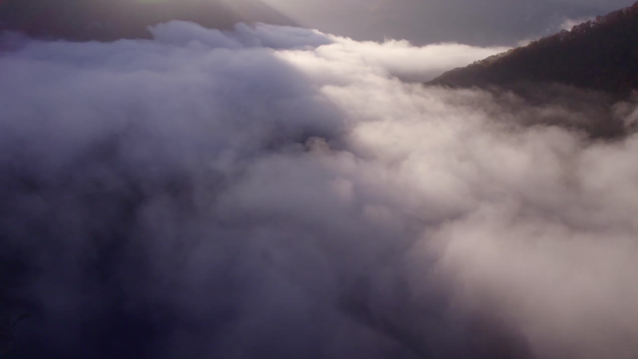 Aerial view of bridge and Piva lake with clouds at sunrise in Pluzine, Montenegro with stunning sunrise lighting, calm atmosphere, high quality drone footage capturing serene moments