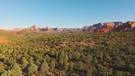 złota godzina światła słonecznego rzuca pustynne alpenglow na krzewy las i podwodnej skały, sedona arizona