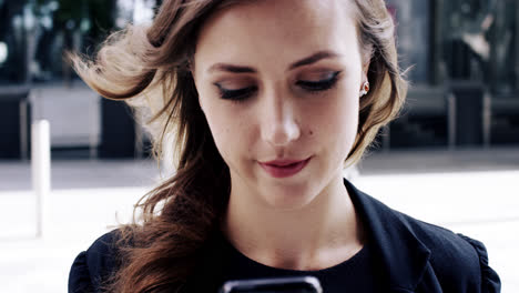 attractive business woman commuter using smartphone in city of london