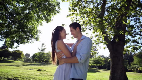 una pareja feliz bailando en el parque.