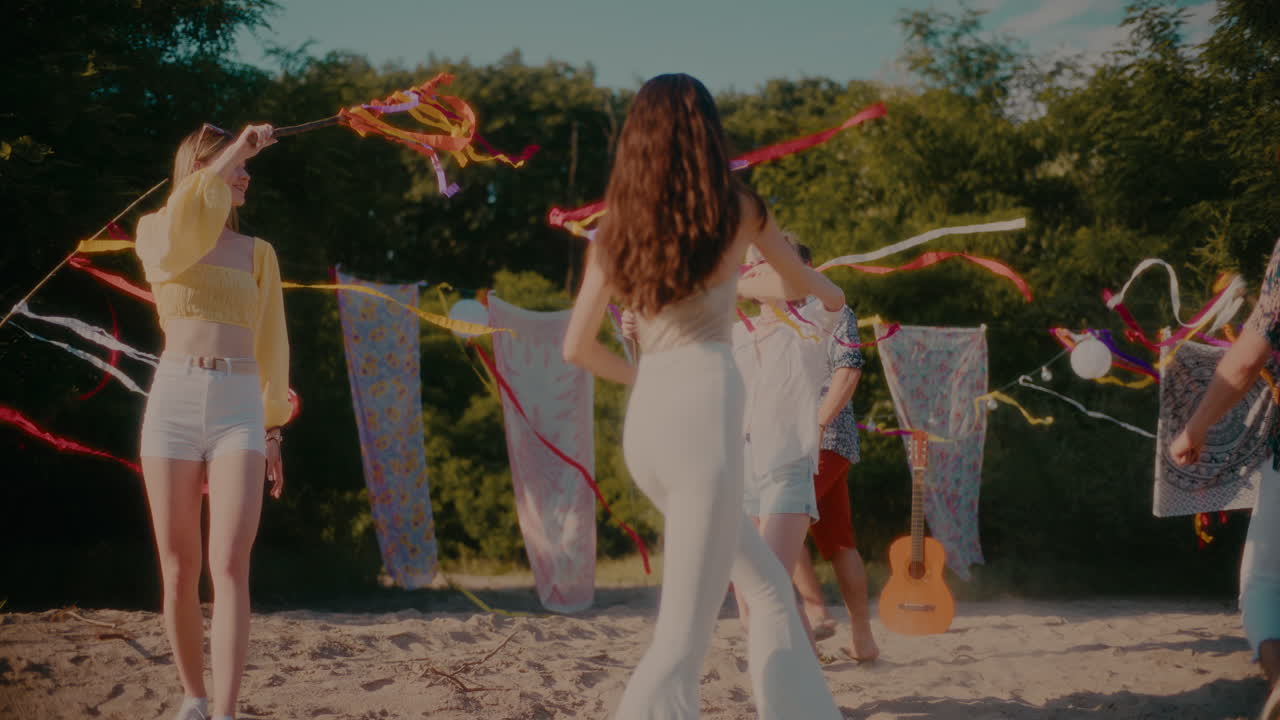 jóvenes amigos felices masculinos y femeninos bailando con cintas