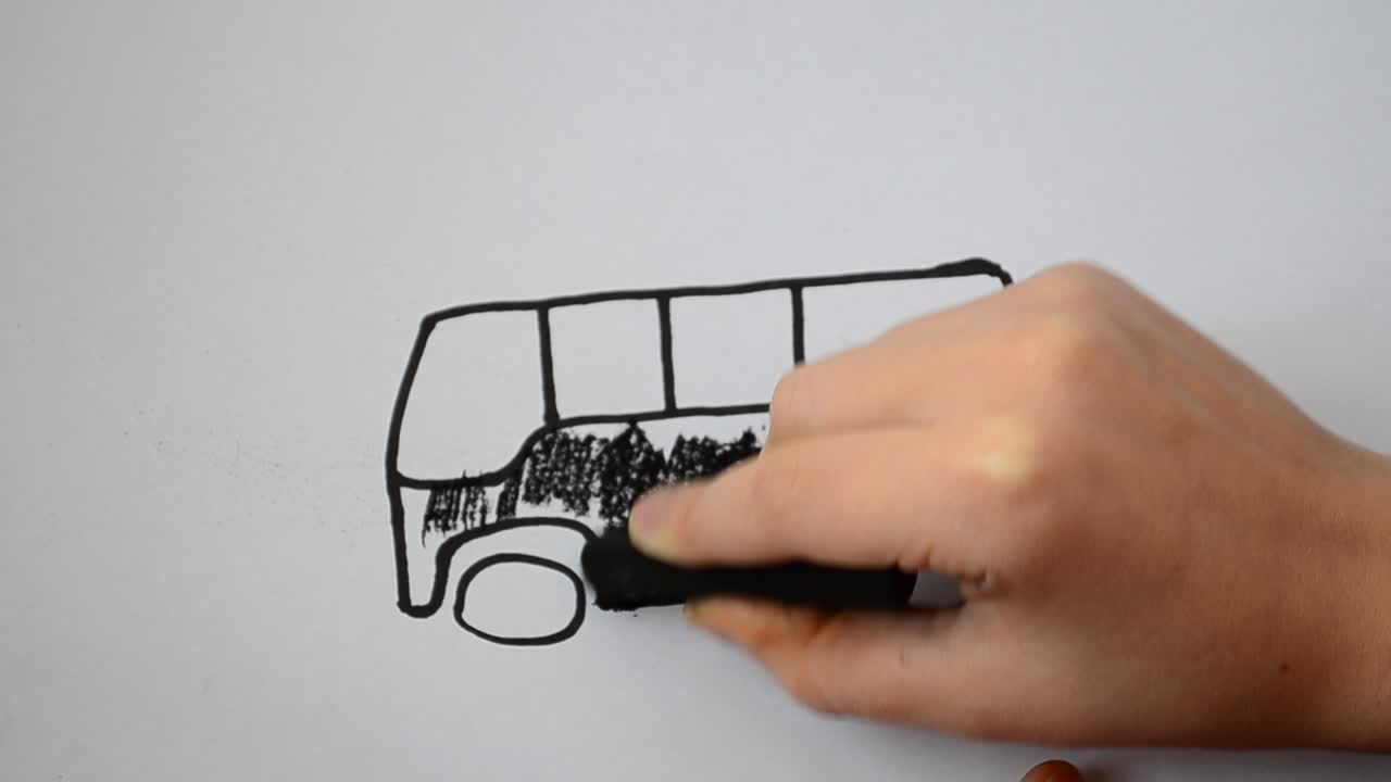 Il bambino disegna l'autobus. Disegno su carta bianca