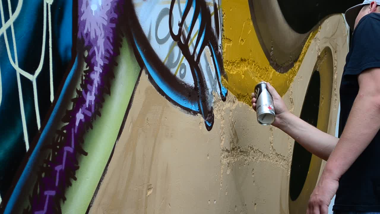 Grafiti en una valla, un fondo. El artista dibuja grafiti