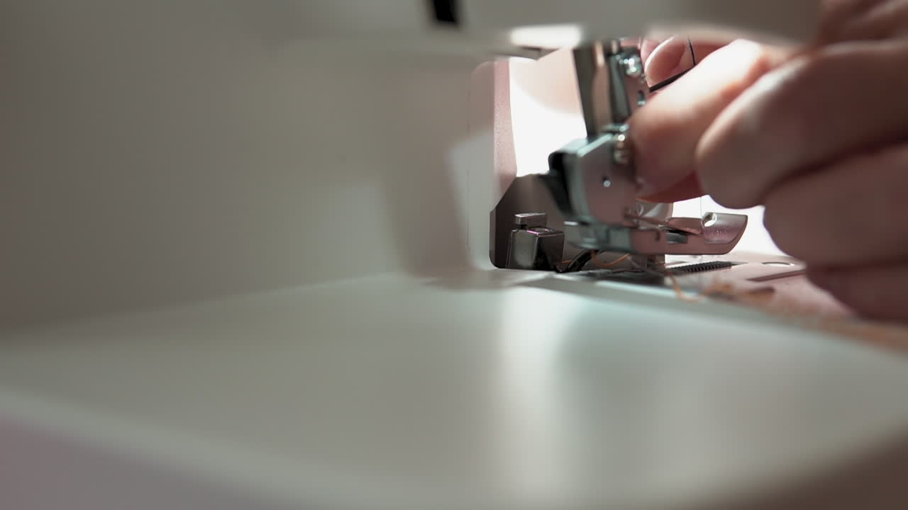 Close Up Of Hands Threading Needle On Foot Of Sewing Machine. Slow Motion