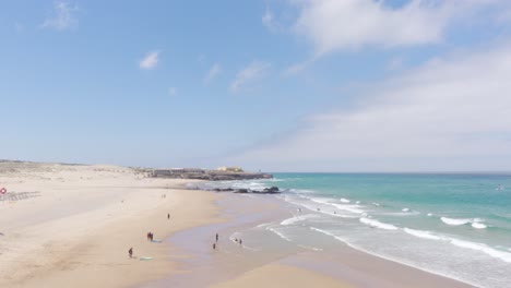 a sunny day at the famous praia do guincho with some surfers by the beach