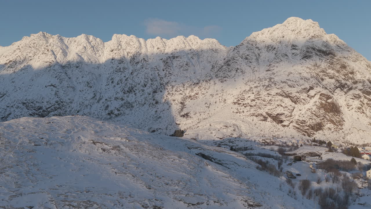 Vista aérea deslumbrante de cordilheiras cobertas de neve em Lofoten, Noruega. Perfeito para documentários de viagem, turismo de inverno e conteúdo de exploração da natureza.