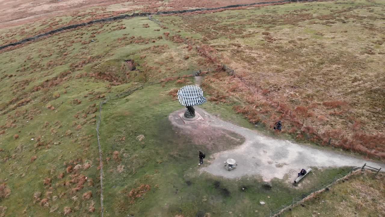 Spinning shot of the Singing Ringing Tree sculpture from above, showing visitors and the surrounding landscape