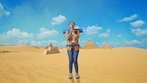 woman praying in front of the pyramids of giza