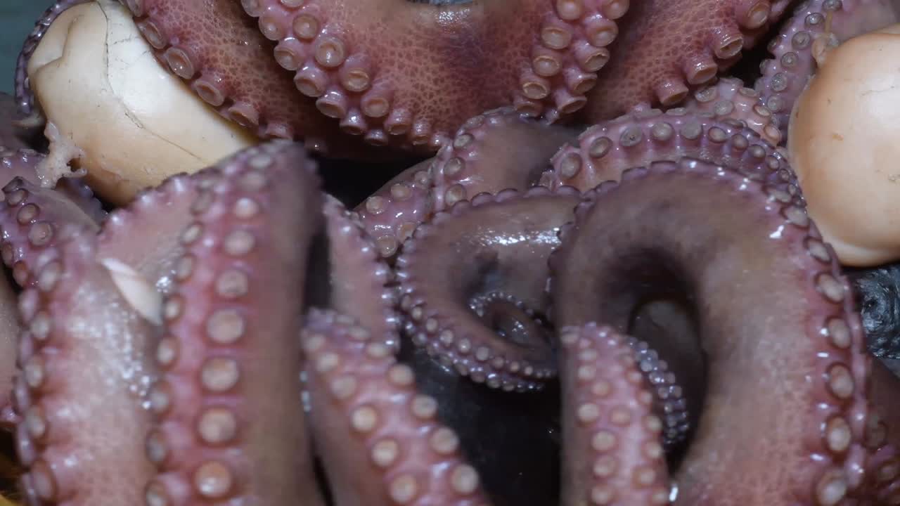 приготовленные целые осьминоги, вращающиеся на кухонной доске для резки