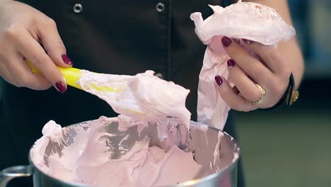 confectioner fills plastic pastry bag with white thick cream