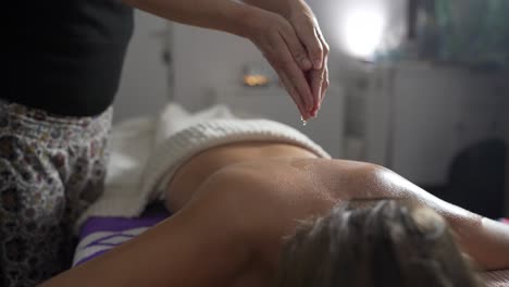 woman massaging back of client in salon