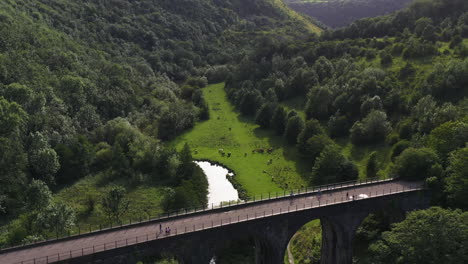 aerial view tilting backwards over the railway viaduct at monsal head, in england