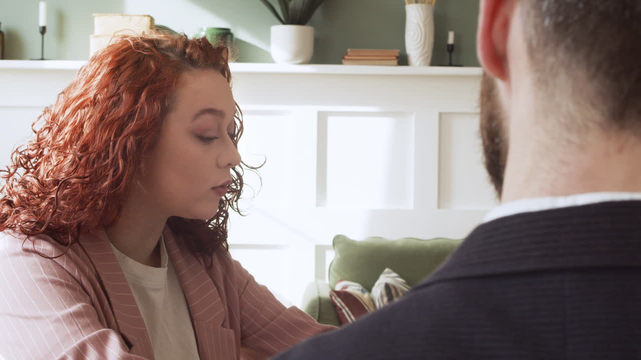 бизнесмен и бизнесвумен сидят за столом и спорят во время собрания коллектива