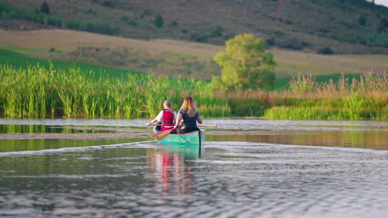 Two people canoeing on a peaceful lake