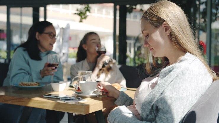 Pregnant woman with friends in a cafe