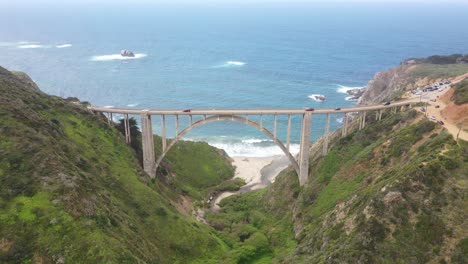 autos conduciendo en el puente bixby creek con un mar azul tranquilo en la costa de big sur, monterey, california