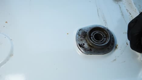 cleaning the dirty surface of a gas stove with a paper towel