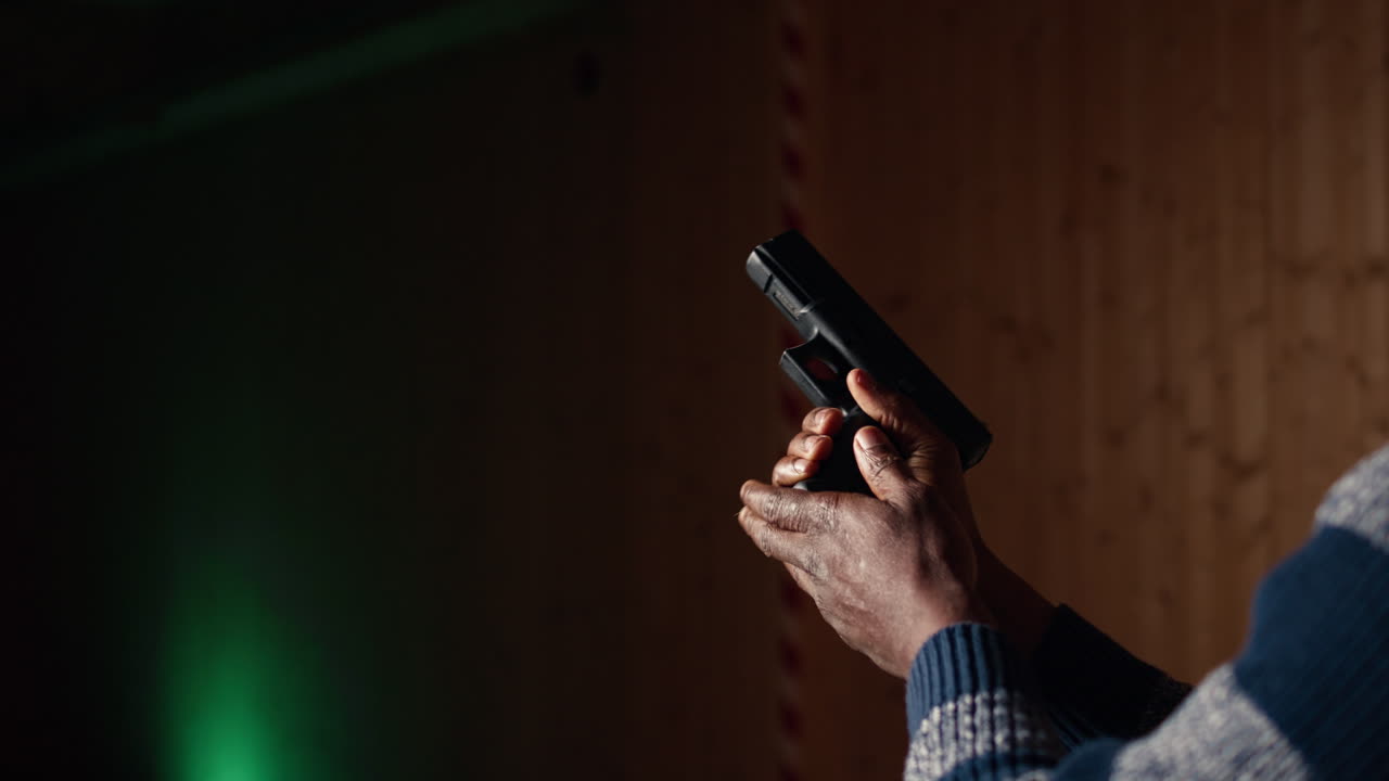 Man reloading handgun in indoor shooting range, close up