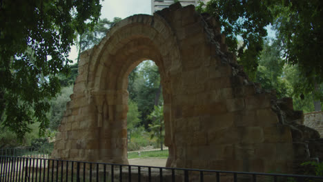 ancient stone archway ruin in a lush park setting