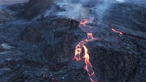 tourist watching viscous lava stream at fagradalsfjall volcano in iceland