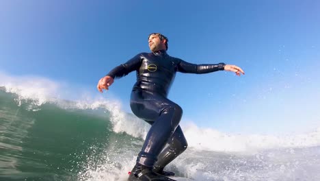 a surfer takes off on a big wave at cascais beach