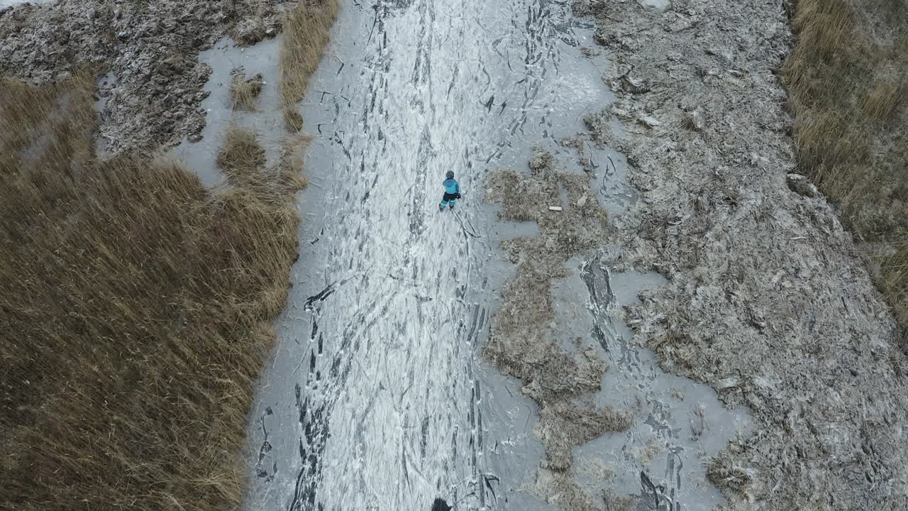 Aerial shot of a small child ice skating with his ice skates at Öckerö Island Municipality in Gothenburg archipelago, Sweden.