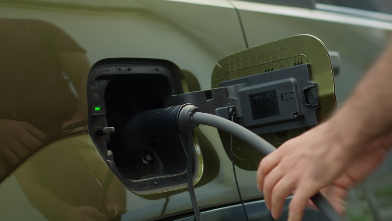 Close Up Of Eco Conscious Driver Opening Charging Port Flap Of Electric Car