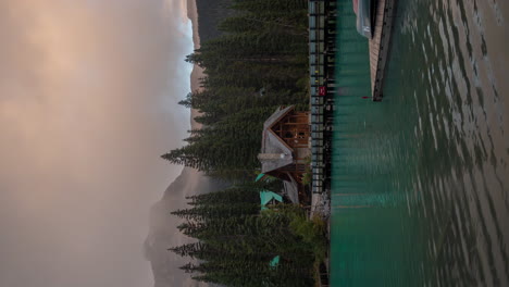 vertical 4k time lapse, serene landscape of yoho national park, emerald lake lodge, canoes, road and clouds moving above mountain peaks