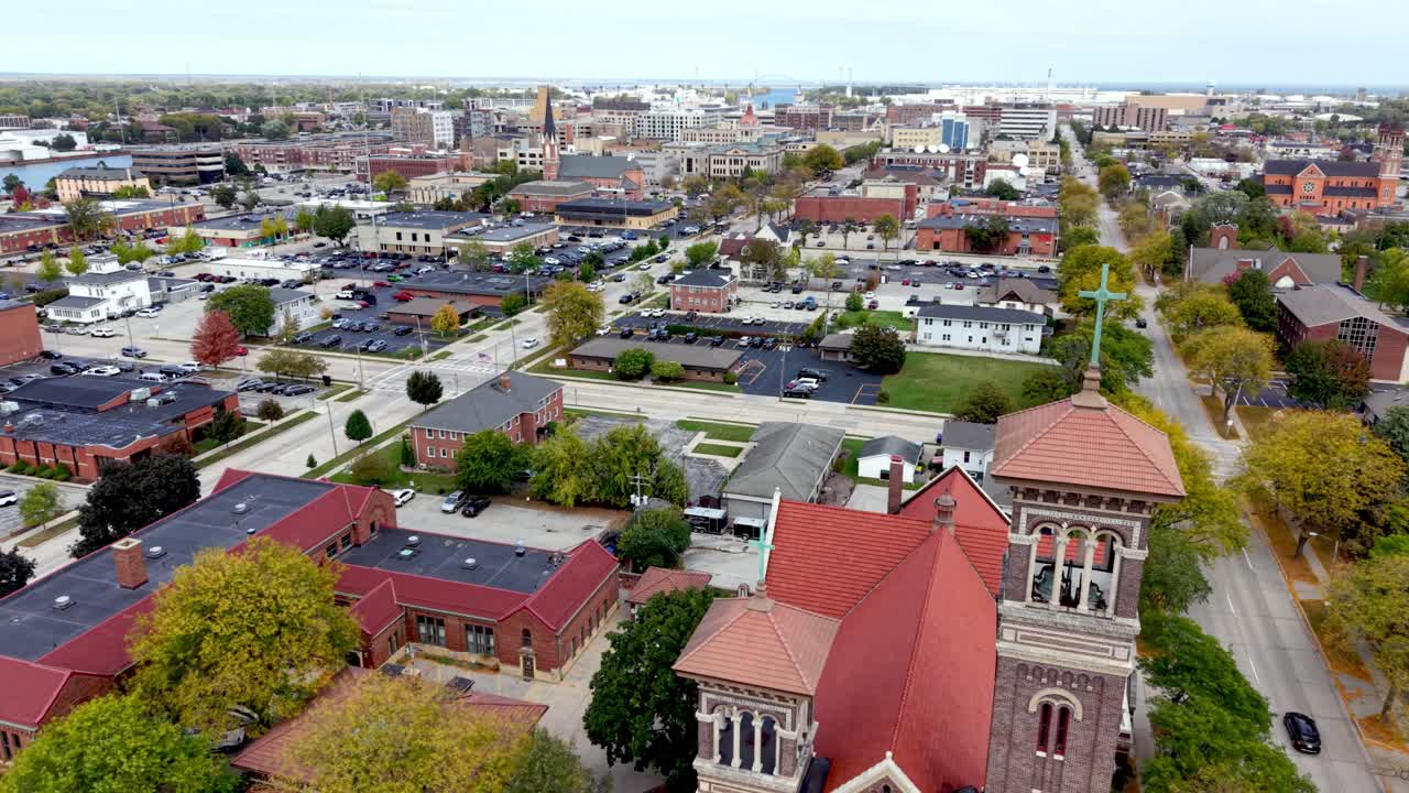 órbita aérea de iglesia con el perfil urbano de la ciudad de Green Bay, Wisconsin, al fondo